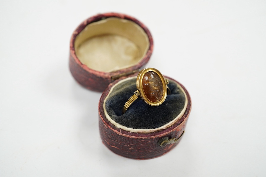 A 19th century French? yellow metal and oval intaglio paste set swivelling ring, size N, gross weight 1.2 grams. Condition - poor to fair